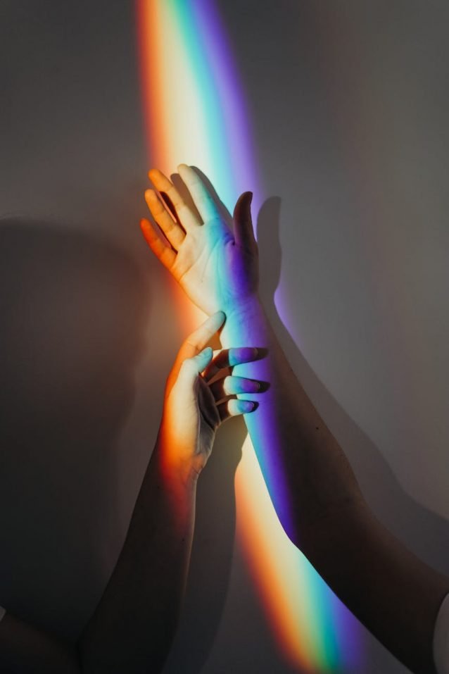 persons hands with rainbow colors